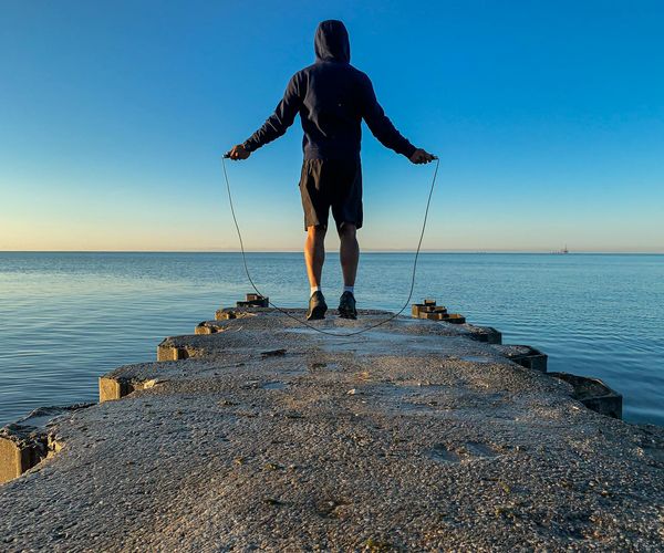 Silhouette of a man stretching against a sunrise, symbolizing energy and vitality.